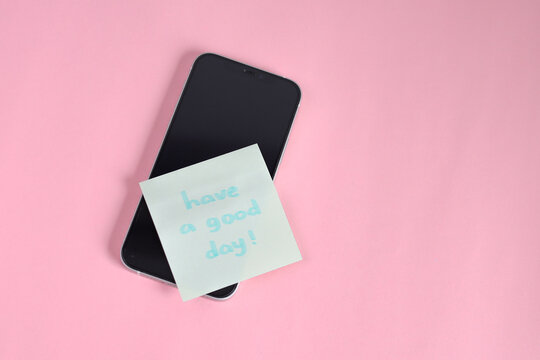 Cheerful Reminder Note Saying Have a Good Day! Placed On Modern Smartphone Against Pink Background - Powered by Adobe
