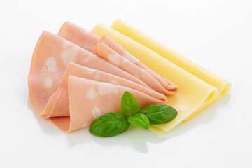Slices of mortadella and cheese with fresh basil leaves