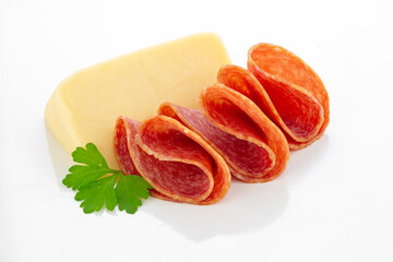 Slices of Hungarian salami with Edam cheese on white background