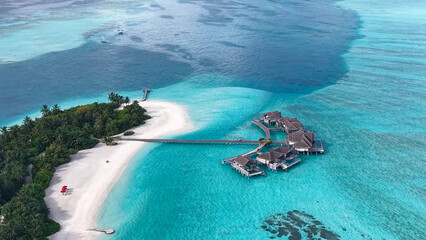 High aerial view of a tropical island split by a bridge, connecting two white sand sections...