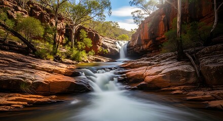 Serene Waterfall Flowing Through Rocky Gorge in Karijini National Park.