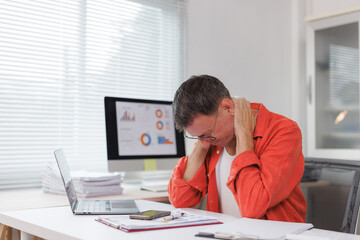 Fototapeta premium Man experiencing neck pain working in office