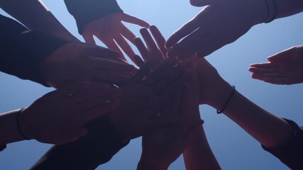 Team huddle hands touch together teamwork spirit blue sky - Powered by Adobe