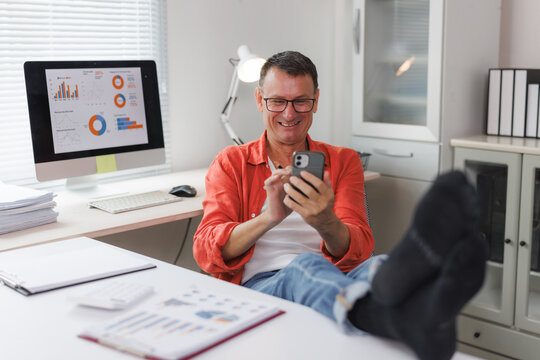 Man relaxing at home office checking phone