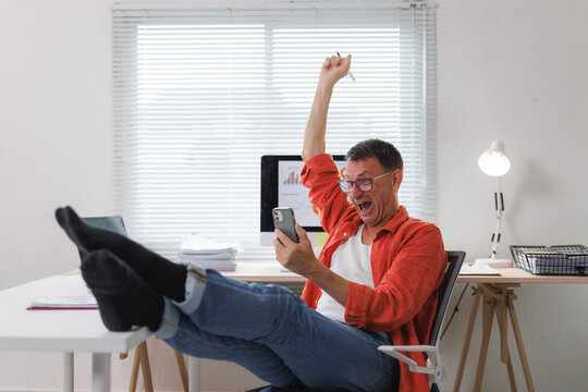 Man celebrating online success viewing smartphone