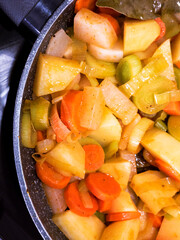 Top view of chopped fresh vegetables frying on a pan. Close up view of delicious and healthy vegetables seasoned.