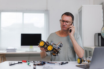 Man calling for help troubleshooting robot car