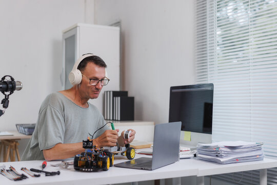 Man soldering wires on a robot car project at home