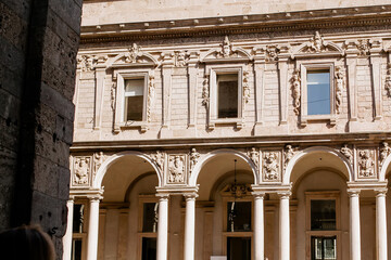 Obraz premium Detailed Close-up of a Grand Historical Palace Facade Featuring Ornate Stone Carvings, White Columns, and Arched Windows, Capturing Renaissance Architecture in Milan, Italy, on October 2, 2025