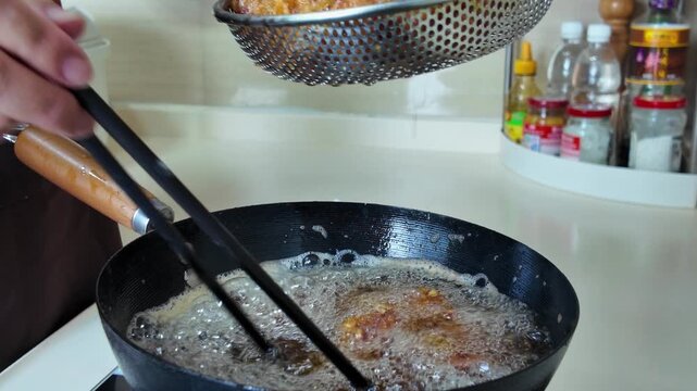 A chef is frying garlic ribs in a pan