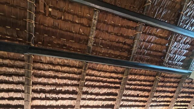 A close-up view of an atap nipah, a roof made from woven nipa palm leaves on a traditional Malaysian house. This once-common roofing keeps the interior of the Malay home cool and comfortable.