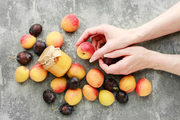 A woman holds colorful fruits in her beautiful hands against the background of fruit lying on a...