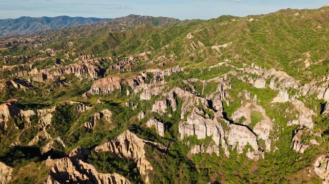 Aerial sideways view of the stunning rock formations and green mountains of los estoraques in colombia