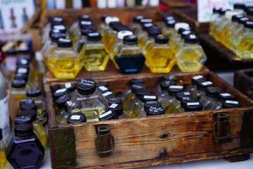 Colorful bottles of essential oils displayed at a local market during the daytime in a vibrant outdoor setting