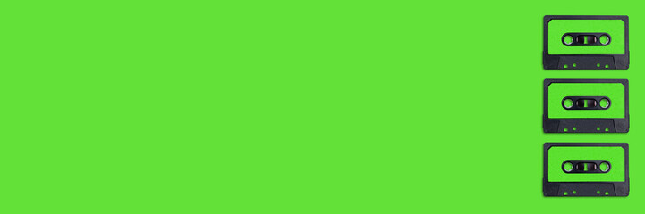 Top view of vintage audio cassette tapes flat lay on colorful green background. Creative 80s Banner. Retro minimal Pop Art design. music concept.