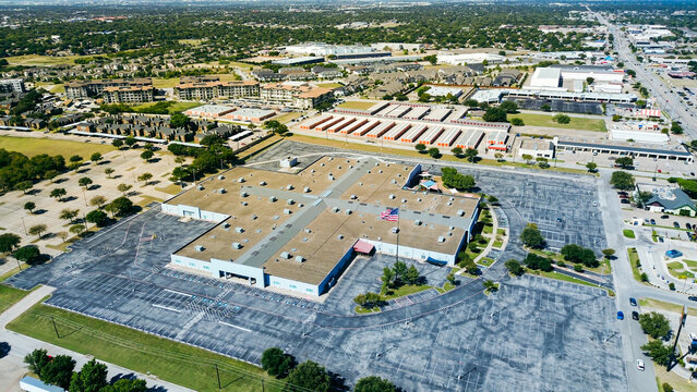 Fototapeta Industrial building flat roof HVAC units, unoccupied parking lot, adjacent storage facility, apartment complex, suburban homes near NE Loop 820 highway-front retail pads, North Richland Hills, TX