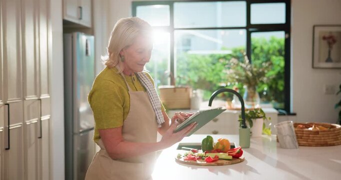 Mature woman, tablet and scroll in kitchen for thinking, vegetables and search for recipe in home. Person, chef and flare for food with tech, ingredients or cooking on app for meal prep in house