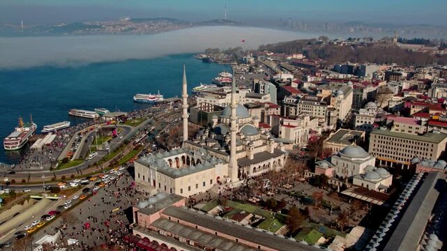 Aerial panorama of Istanbul featuring Eminonu, the New Mosque, Galata Bridge and Topkapi Palace surrounded by morning fog over the Bosphorus &mdash; blending history, sea and city life.