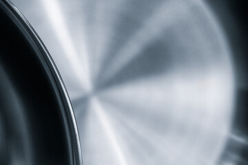 Silver frying pan with black rim. The frying pan is shiny and has a smooth surface as an abstract metallic texture background for web banner template page design