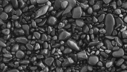 A collection of wet, black white smooth sea stones. The concept of tranquility and serenity serves as a textured backdrop for a web banner page template design