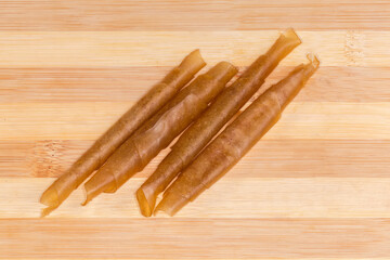 Twisted apple pastila rolled into tubes on a cutting board