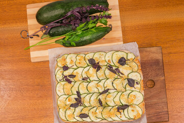 Zucchini pizza on cutting board and fresh zucchini, top view