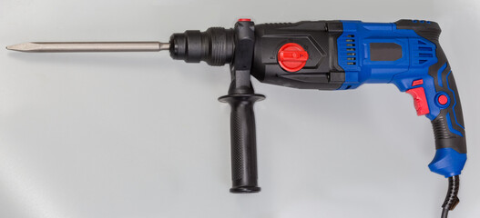 Electric rotary hammer drill with inserted pointed chisel, side view