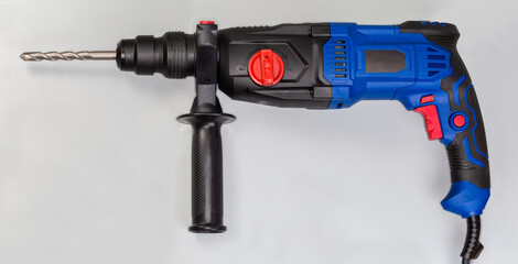 Electric rotary hammer with inserted concrete drill bit, side view