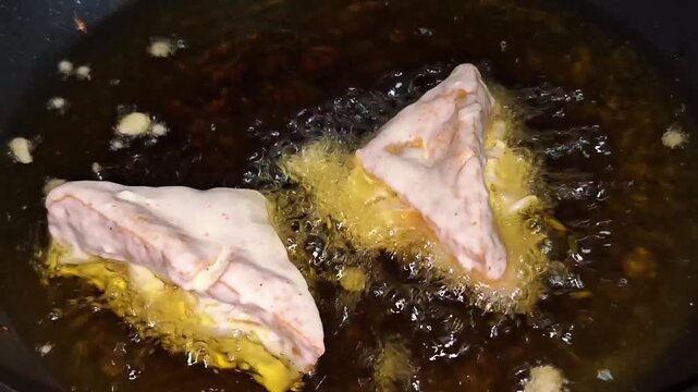 Making Indonesian stuffed tofu: filling tofu with vegetables, dipping it in batter, and frying it in a wok.