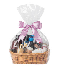 Gift basket with cosmetic bottles and jars wrapped in transparent cellophane with pink satin ribbon