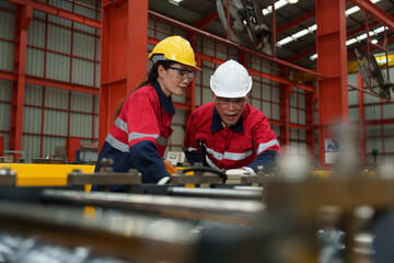 Engineers and staff inspect the production line of components in a metal sheet and metal roofing manufacturing plant.