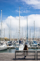 Serene moment at the harbor watching sailboats sway under a sunny blue sky, providing a calming escape and a feeling of peaceful contemplation