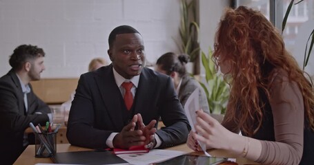 Diverse colleagues brainstorm and analyze data in a co working space coffee bar. Discussing ideas and startup business in a diverse team. - Powered by Adobe