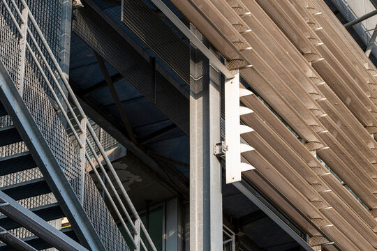 Modern architectural structure combining steel grids, vertical panels, and wooden slats in an expressive dialogue between materiality, geometry, and industrial design aesthetics