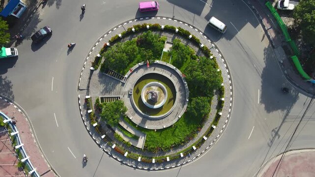 A perfect top-down aerial view of the President Francisco Xavier do Amaral roundabout in Dili, Timor-Leste. This bird's-eye perspective captures the perfect circular pattern of traffic.