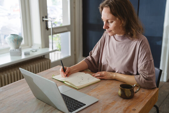 Creative entrepreneur sketching ceramic design in studio workspace