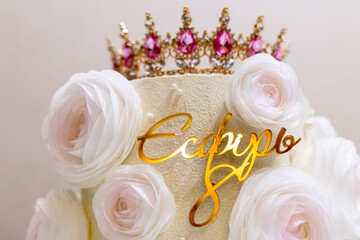 Elegant cake adorned with white roses and a sparkling crown, perfect for a royal celebration or a special occasion.