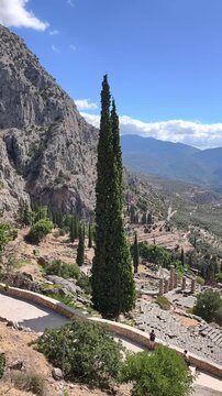 Ancient stone columns and ruins of the Temple of Apollo at Delphi, Greece. Historic archaeological, Mount Parnassus, surrounded by rocky cliffs and cypress trees. famous for the Oracle of Delphi.