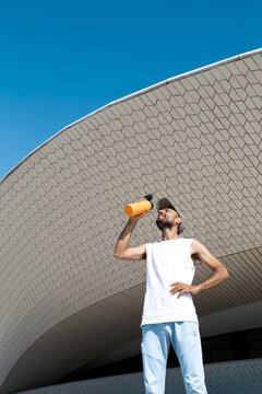 Runner hydrating after morning run at MAAT Lisbon in summer