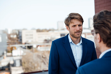 Business professionals communicating outdoors in urban setting