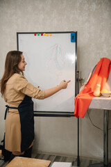 Education and learning concept. Female is drawing a picture in art class. Woman painting in a workshop. Girl mixing and combining colors. Art lesson. People drawing with brush on easel.