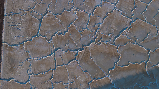Aerial view of cracked earth like a parched canvas, revealing intricate patterns etched by the sun's relentless kiss, Sunnyvale, California, United States.