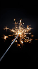 Sparkler casting golden light trails and bright sparks against a dark background, evoking festive joy, celebration, warm glow, and magical holiday moments