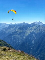Summer landscape with green mountains, paragliding, and alpine meadows in Austria and Germany