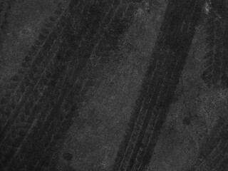 Close up black tire marks on cement floor.