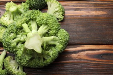 Fresh raw broccoli on wooden table, flat lay. Space for text