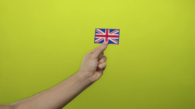 Man holding embroidered great britain flag on yellow background showing national pride with detail and simplicity
