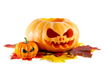 Halloween pumpkin with a scary face and autumn leaves isolated on white background.