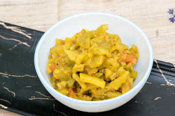 white bowl filled with dry Lauki ki Sabji (bottle gourd stir-fry), served on a sleek black tray. simple, healthy, no-onion, no-garlic Indian vegetable dish is lightly spiced perfect for satvic meal.