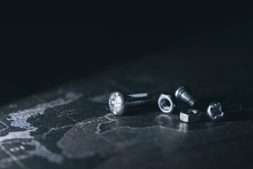 Close up of metal nut, bolt, and screw on dark industrial background. Concept of repair, construction, and hardware with dramatic lighting and copy space